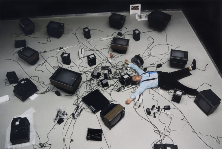 Nam-June-Paik-lying-among-televisions-768x516